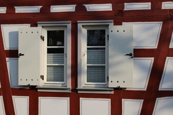 weiße Sprossenfenster mit Klappläden